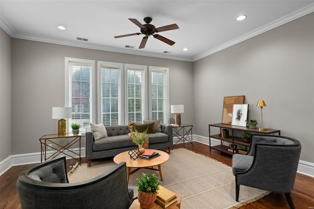 living area with ornamental molding, visible vents, baseboards, and wood finished floors