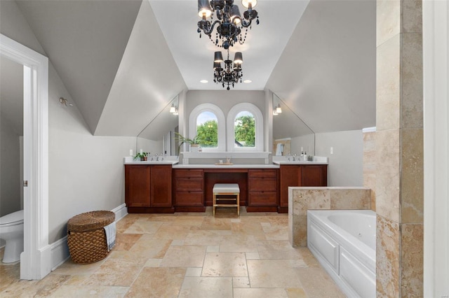 full bathroom with a garden tub, double vanity, toilet, an inviting chandelier, and baseboards