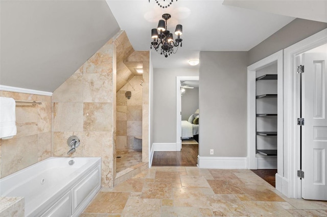 ensuite bathroom featuring stone tile floors, connected bathroom, a garden tub, a tile shower, and tile walls