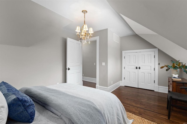 bedroom with visible vents, vaulted ceiling, baseboards, and wood finished floors