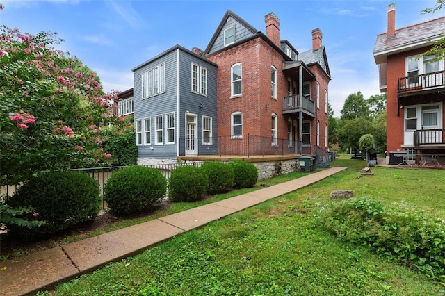 exterior space with a yard, brick siding, and a chimney