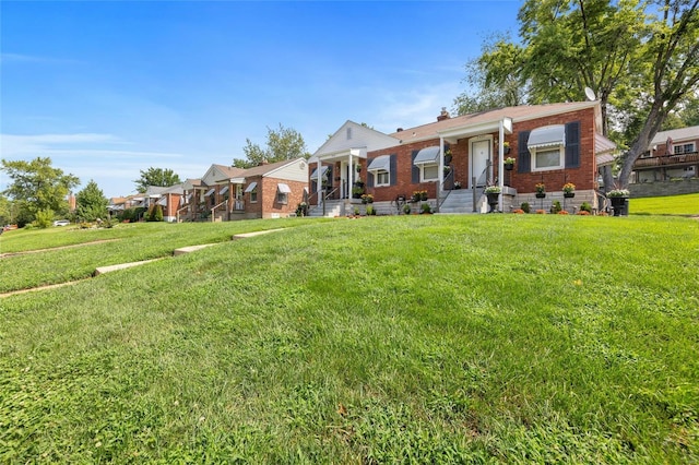 view of front of house featuring a front yard, brick siding, a residential view, and a chimney