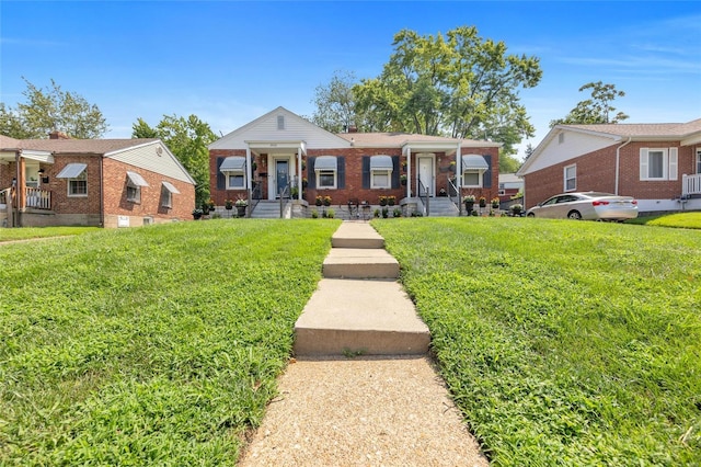 bungalow with brick siding and a front lawn