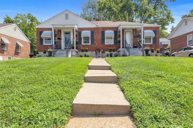 view of front facade with brick siding, a chimney, and a front lawn