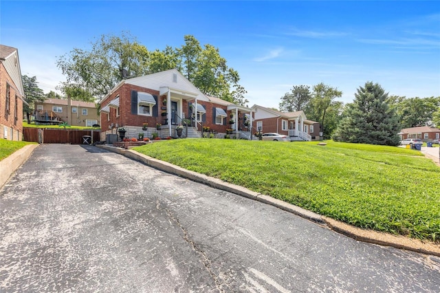 view of front facade featuring brick siding, a front lawn, and a residential view