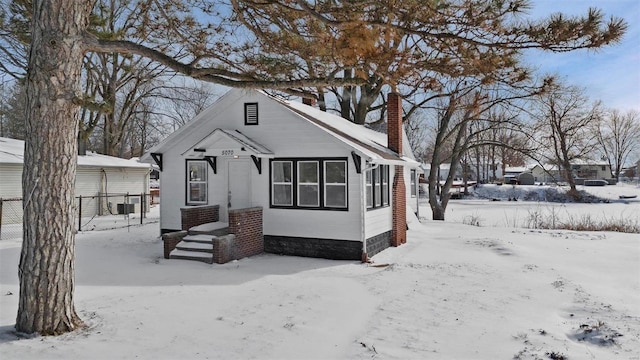 view of front of house with a chimney and fence