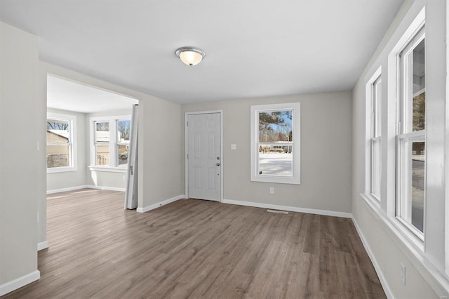 entrance foyer with wood finished floors, visible vents, and baseboards