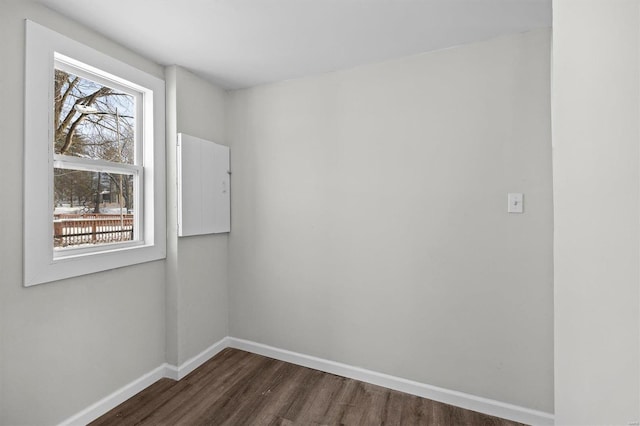 empty room featuring dark wood-style floors and baseboards