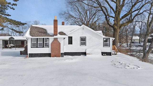 snow covered property featuring a chimney