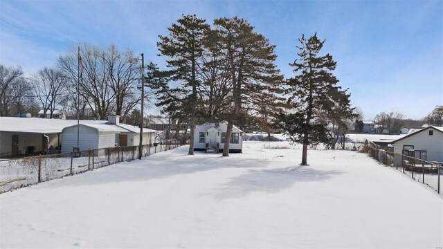 yard layered in snow featuring fence and a residential view