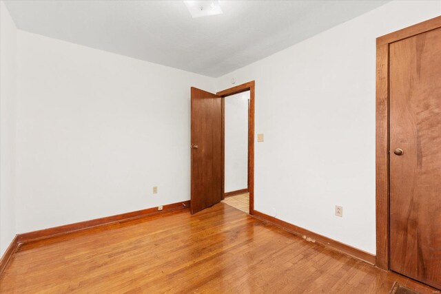 spare room with light wood-style floors and baseboards