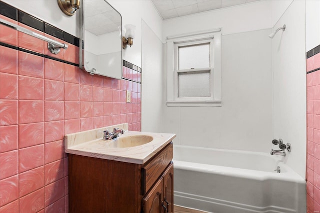 bathroom with vanity, tile walls, and bathing tub / shower combination