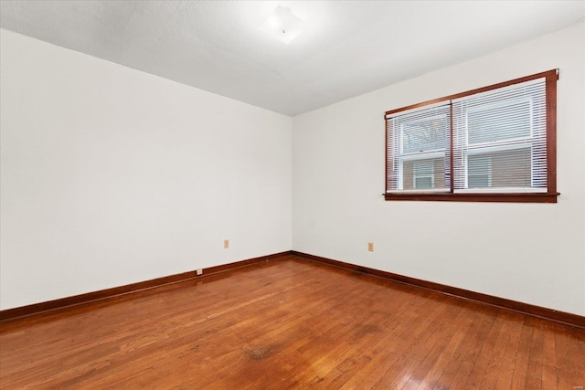 empty room featuring hardwood / wood-style flooring and baseboards