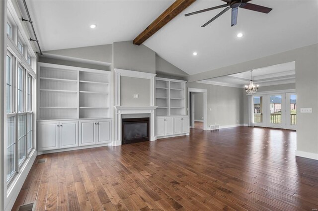 unfurnished living room with ceiling fan with notable chandelier, visible vents, dark wood-style floors, beamed ceiling, and a glass covered fireplace