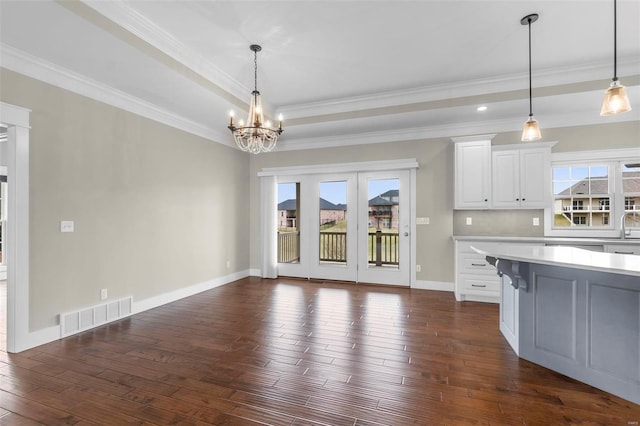 kitchen with light countertops, dark wood-style flooring, plenty of natural light, and visible vents