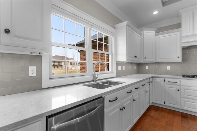 kitchen featuring a sink, white cabinets, ornamental molding, backsplash, and dishwasher