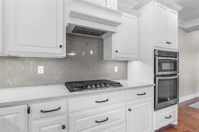 kitchen featuring appliances with stainless steel finishes, dark wood-style flooring, crown molding, premium range hood, and white cabinetry