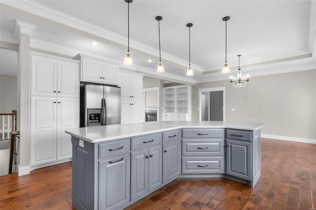 kitchen featuring gray cabinetry, white cabinets, a center island, stainless steel fridge, and a raised ceiling