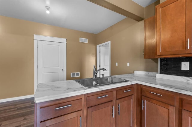 kitchen with a peninsula, visible vents, backsplash, and a sink