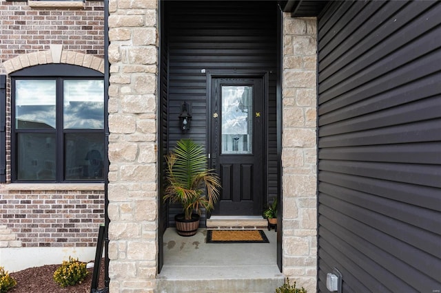 view of exterior entry with brick siding and stone siding