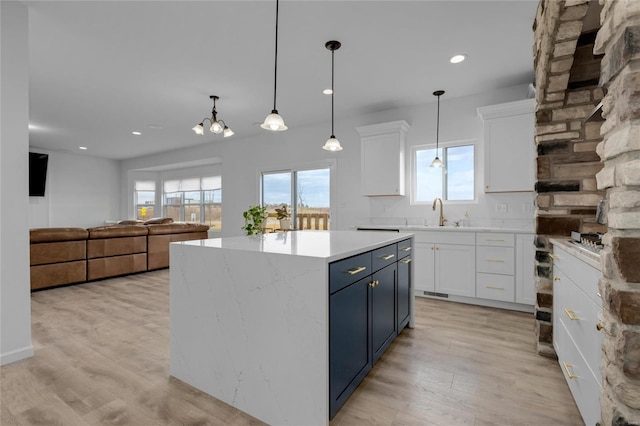 kitchen featuring white cabinetry, light countertops, blue cabinets, and light wood-type flooring