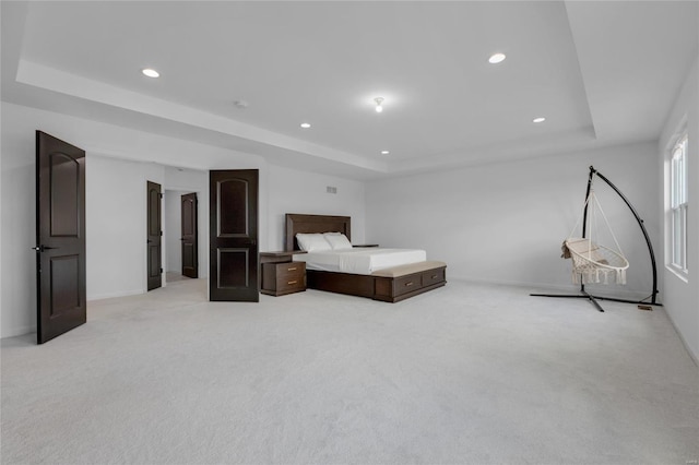 bedroom featuring recessed lighting, light colored carpet, a raised ceiling, and baseboards