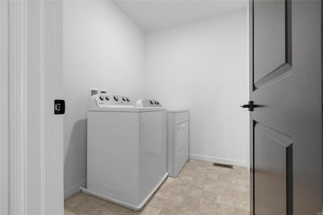 washroom with washer and dryer, laundry area, baseboards, and visible vents