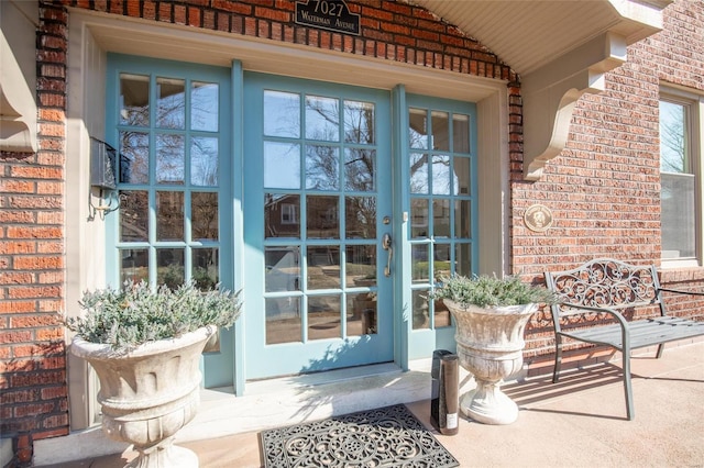 property entrance with brick siding and french doors