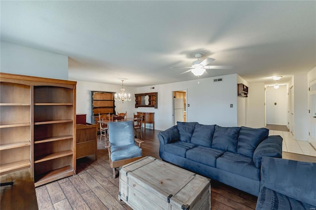 living room with ceiling fan with notable chandelier, wood finished floors, and visible vents