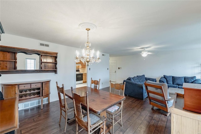 dining space featuring visible vents, dark wood finished floors, and ceiling fan with notable chandelier