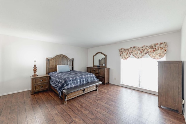 bedroom with dark wood finished floors and baseboards