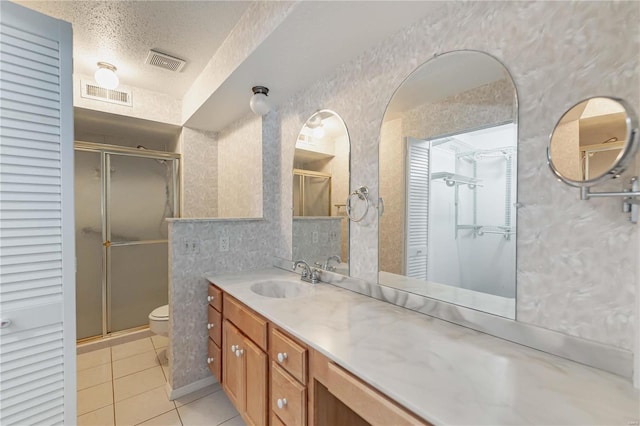 full bathroom with a textured ceiling, a stall shower, tile patterned flooring, and visible vents