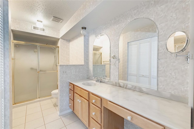 full bathroom featuring a textured ceiling, toilet, a shower stall, and visible vents