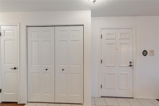 interior space featuring a textured ceiling, a closet, and baseboards