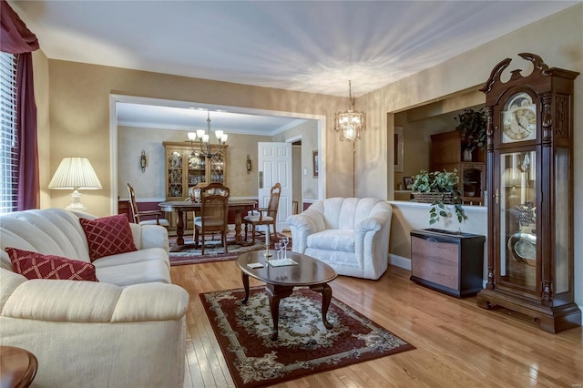 living room featuring a notable chandelier, crown molding, and hardwood / wood-style flooring