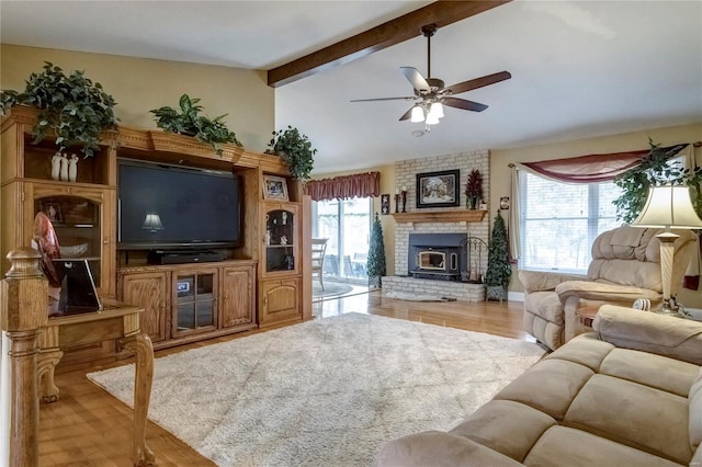 living area with a brick fireplace, vaulted ceiling with beams, a ceiling fan, and wood finished floors