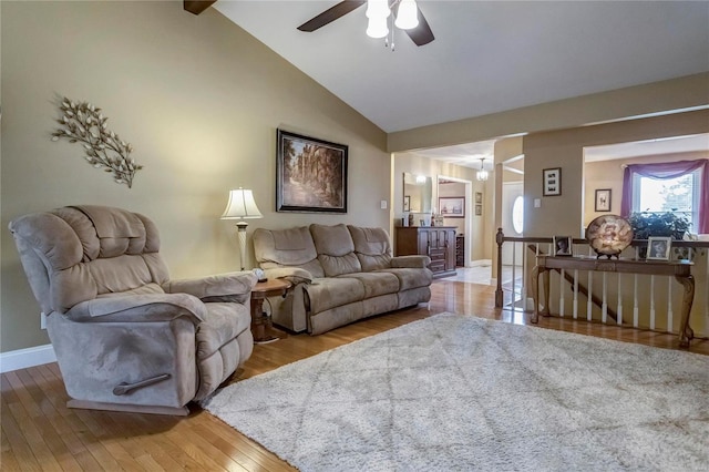 living area featuring ceiling fan, high vaulted ceiling, light wood-type flooring, and baseboards