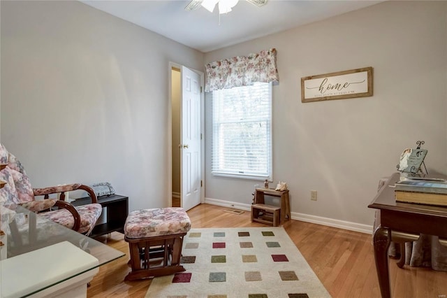 sitting room featuring light wood finished floors, visible vents, a ceiling fan, and baseboards