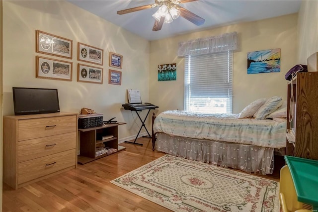 bedroom featuring ceiling fan, baseboards, and wood finished floors