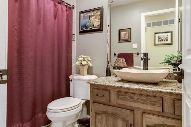 bathroom with visible vents, curtained shower, toilet, and vanity