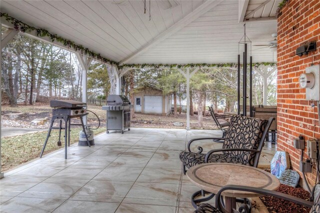 view of patio featuring outdoor dining space and an outbuilding