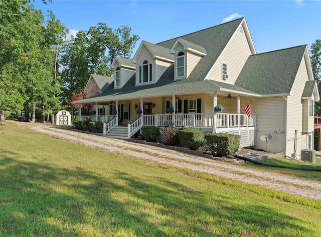 cape cod-style house featuring an outbuilding, a porch, a storage shed, central AC, and a front lawn