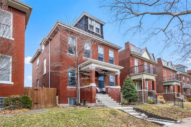 american foursquare style home featuring brick siding and fence