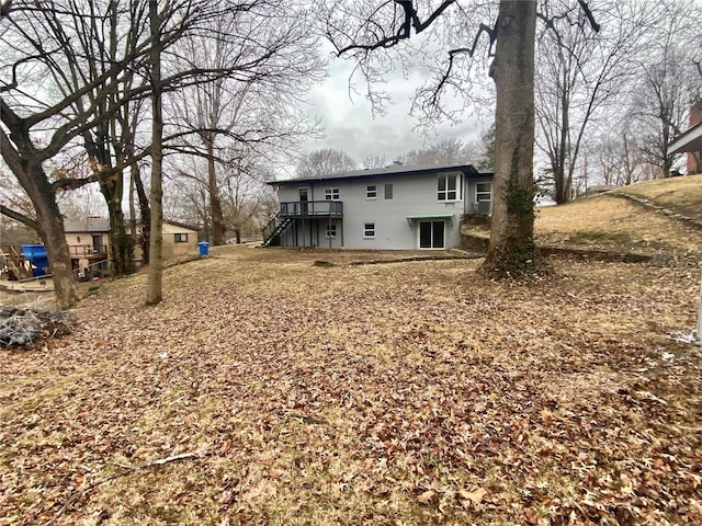 back of property with a wooden deck and stairs