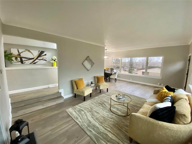 living area with visible vents, baseboards, and wood finished floors