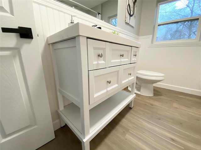 full bath featuring wood finished floors, vanity, toilet, and baseboards