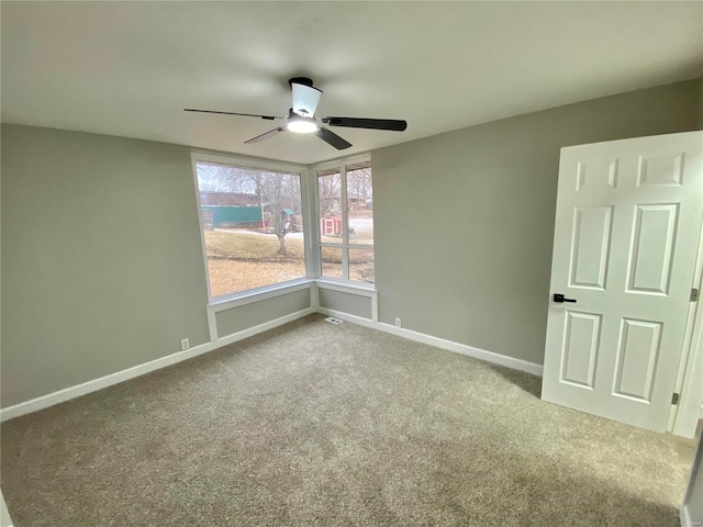 unfurnished room featuring ceiling fan, carpet floors, and baseboards