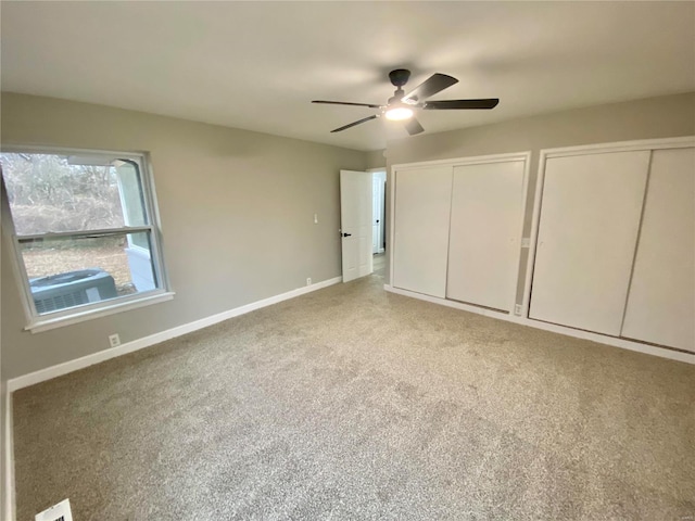 unfurnished bedroom with a ceiling fan, baseboards, multiple closets, and light colored carpet