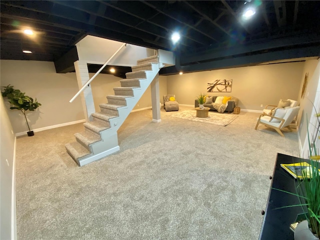 finished below grade area featuring carpet floors, baseboards, and stairway