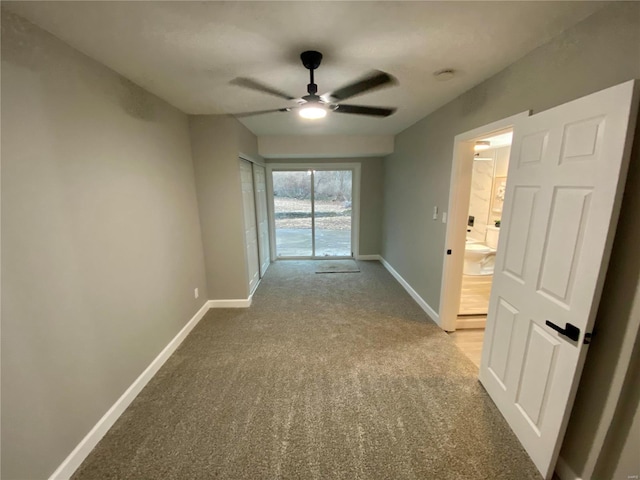 unfurnished room featuring carpet floors, baseboards, and a ceiling fan